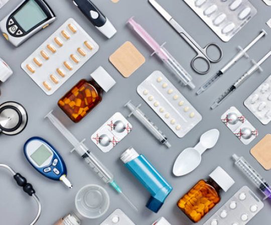 Directly above flat lay flat lay shot of various medical supplies. Full frame shot of medicines placed with syringes and diagnostic tools. All are on gray background.  Knolling concept.